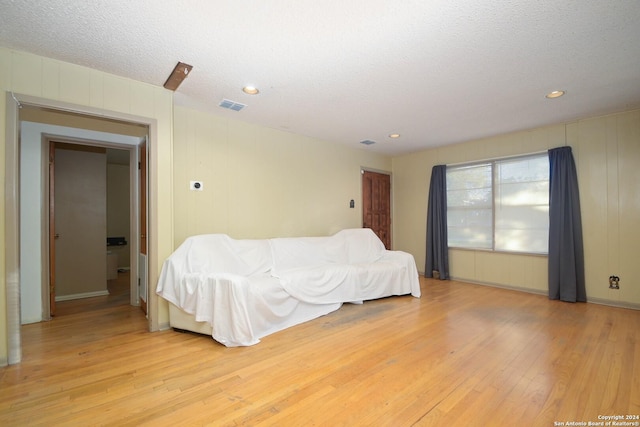 bedroom with a textured ceiling and light wood-type flooring