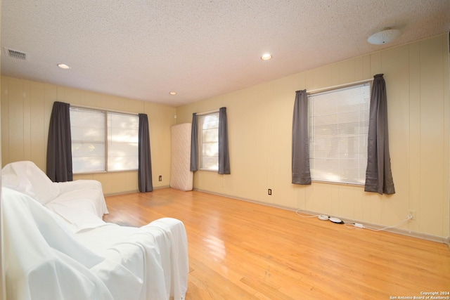 living area featuring a textured ceiling and light hardwood / wood-style flooring