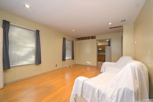 living room with a textured ceiling and light hardwood / wood-style floors