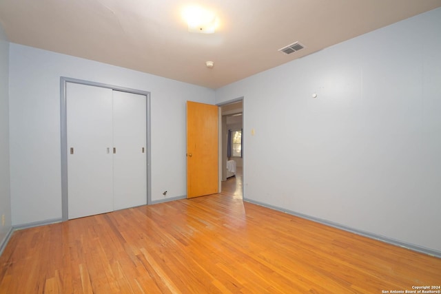 unfurnished bedroom featuring a closet and light hardwood / wood-style flooring