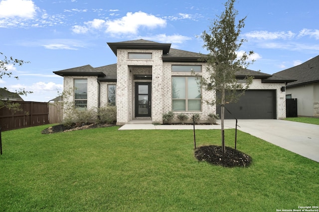 prairie-style home featuring a garage and a front yard