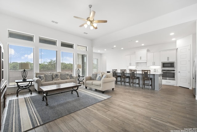 living room with ceiling fan and dark wood-type flooring