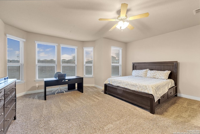 bedroom with multiple windows, light colored carpet, and ceiling fan