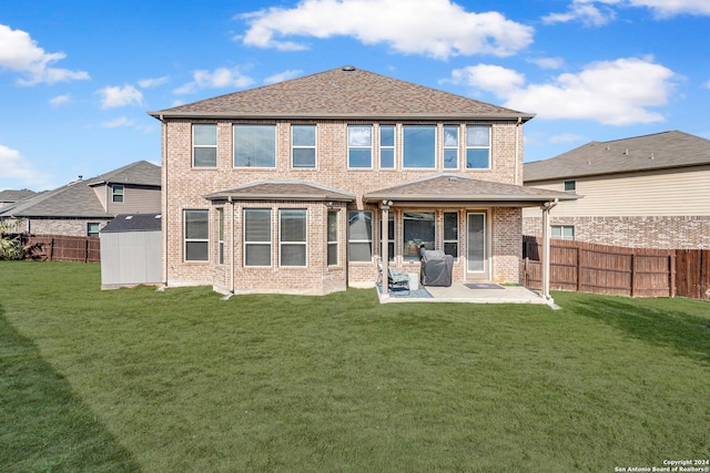 rear view of house with a storage shed, a patio area, and a lawn