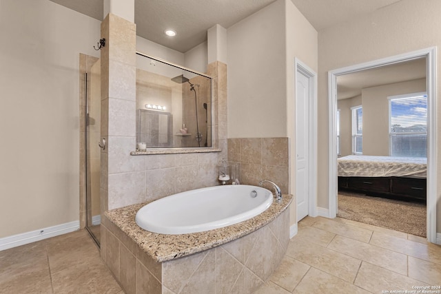 bathroom featuring tile patterned flooring, a textured ceiling, and independent shower and bath