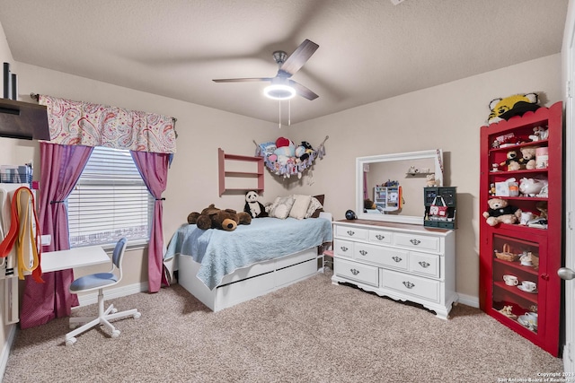 bedroom with ceiling fan, light colored carpet, and a textured ceiling