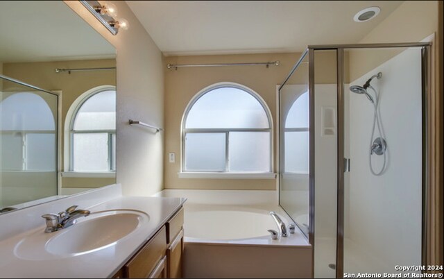 bathroom with vanity and independent shower and bath