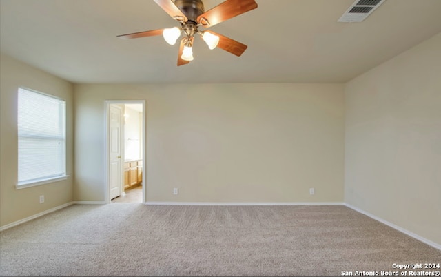 carpeted spare room featuring ceiling fan