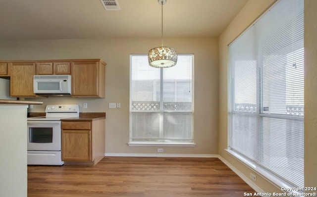 kitchen with white appliances, light hardwood / wood-style floors, and hanging light fixtures