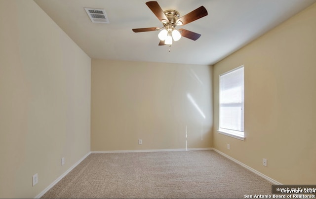 carpeted spare room featuring ceiling fan