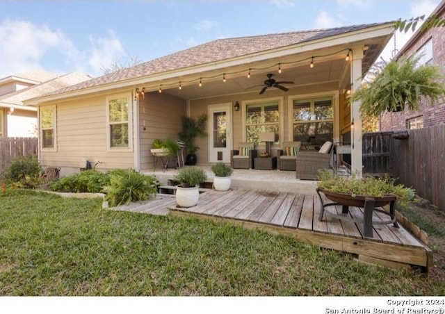 rear view of property with a lawn, a wooden deck, ceiling fan, and an outdoor hangout area