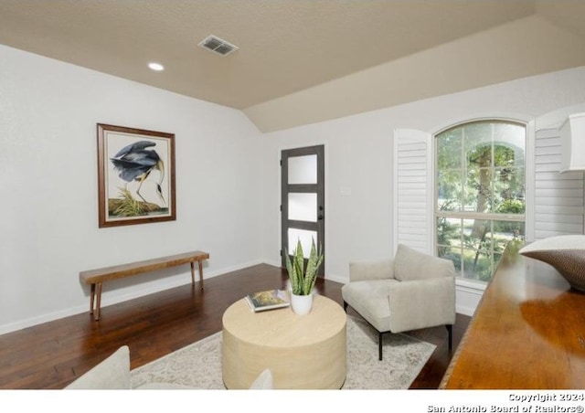 living room featuring dark hardwood / wood-style flooring and vaulted ceiling