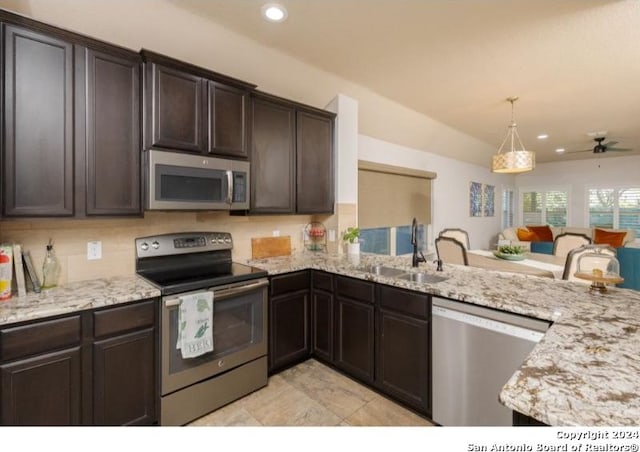 kitchen featuring sink, kitchen peninsula, decorative light fixtures, dark brown cabinetry, and stainless steel appliances