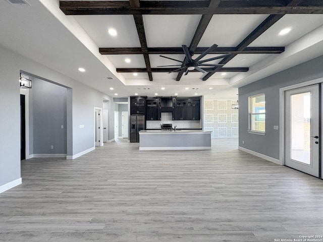 unfurnished living room featuring beamed ceiling, ceiling fan, light hardwood / wood-style floors, and coffered ceiling