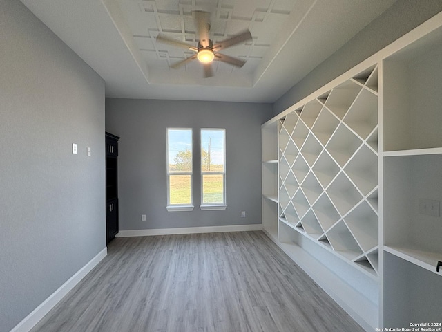 unfurnished room with a tray ceiling, ceiling fan, and hardwood / wood-style floors