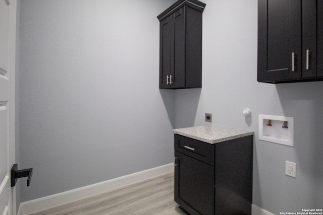 washroom featuring hookup for a washing machine, light hardwood / wood-style flooring, cabinets, and hookup for an electric dryer