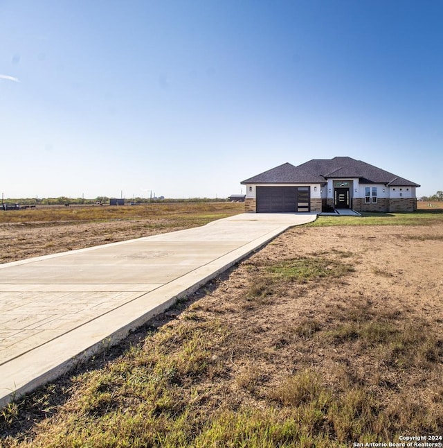 view of yard featuring a rural view and a garage