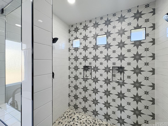 bathroom featuring a tile shower and a wealth of natural light