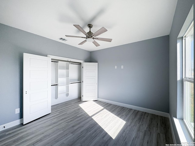 unfurnished bedroom featuring ceiling fan, dark hardwood / wood-style floors, and a closet