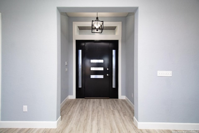 foyer featuring an inviting chandelier and light hardwood / wood-style flooring