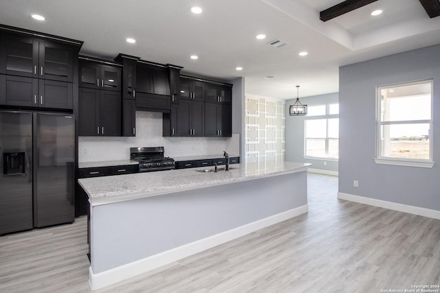 kitchen featuring light hardwood / wood-style floors, sink, an island with sink, and appliances with stainless steel finishes