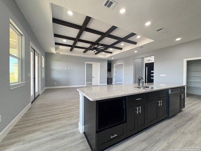 kitchen featuring ceiling fan, sink, coffered ceiling, a center island with sink, and light wood-type flooring