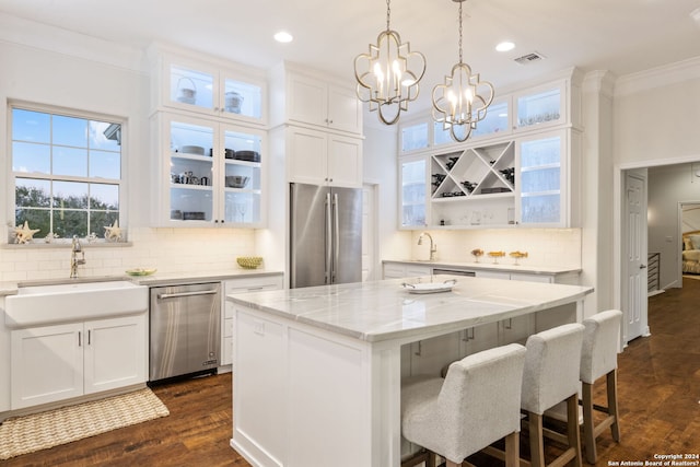 kitchen with stainless steel appliances, dark wood-type flooring, sink, white cabinets, and a kitchen island