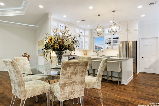 dining area featuring dark hardwood / wood-style floors, crown molding, and a chandelier