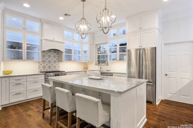 kitchen with dark wood-type flooring, crown molding, a center island, and stainless steel appliances