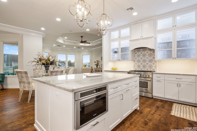 kitchen with backsplash, stainless steel appliances, white cabinetry, and dark hardwood / wood-style floors