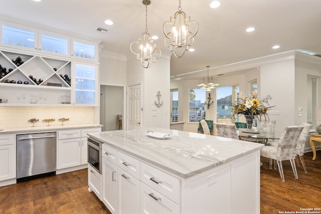 kitchen featuring appliances with stainless steel finishes, dark wood-type flooring, crown molding, white cabinets, and a kitchen island