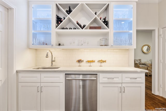 bar featuring dark wood-type flooring, sink, stainless steel dishwasher, tasteful backsplash, and white cabinetry