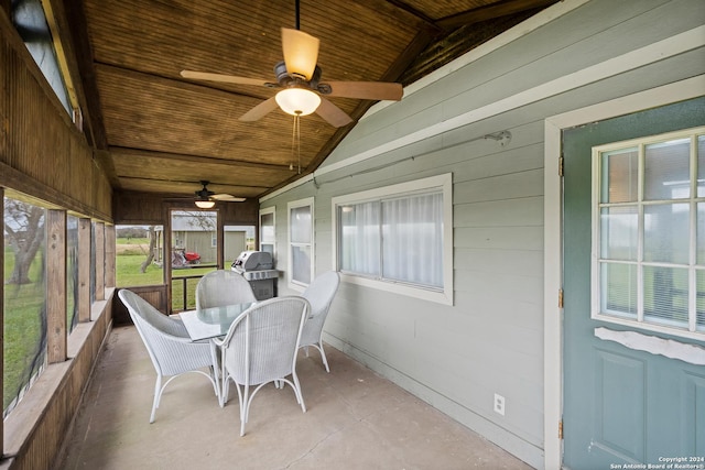 sunroom with vaulted ceiling, ceiling fan, and wood ceiling