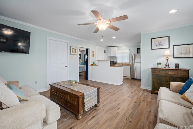 living room with light wood-type flooring, ceiling fan, and crown molding