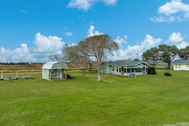 view of yard featuring a sunroom and a storage unit