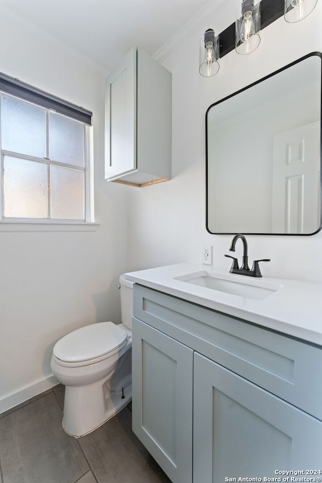 bathroom with vanity, toilet, and crown molding