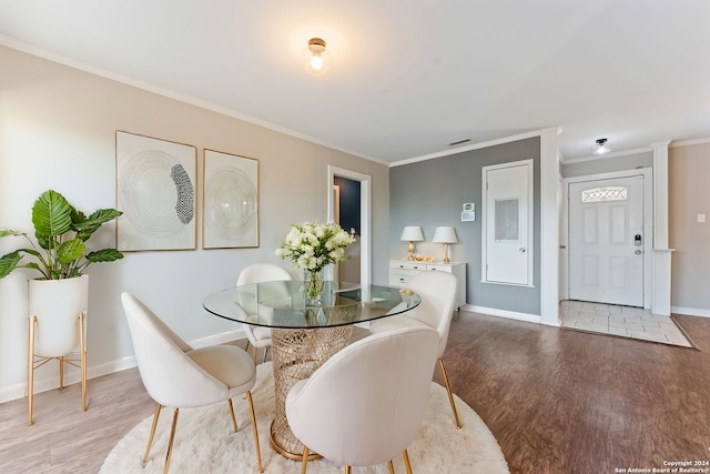 dining space featuring hardwood / wood-style flooring and ornamental molding