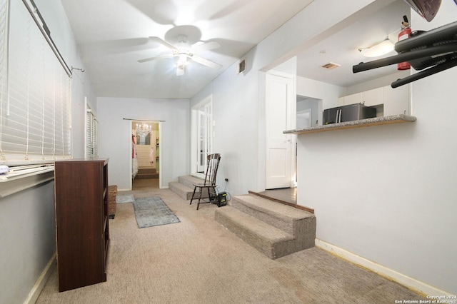 interior space featuring ceiling fan and light carpet