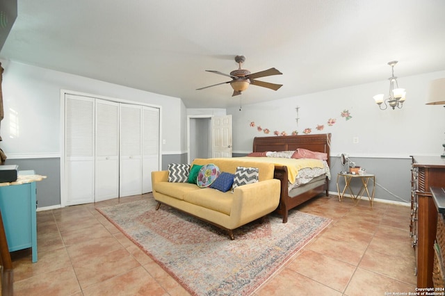 bedroom featuring a closet, light tile patterned flooring, and ceiling fan with notable chandelier