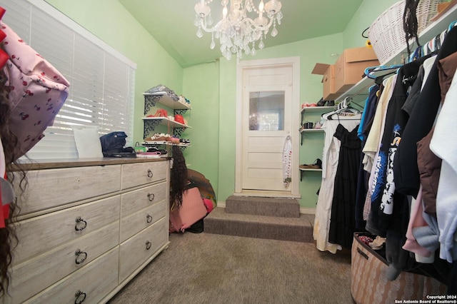 spacious closet featuring an inviting chandelier and dark carpet