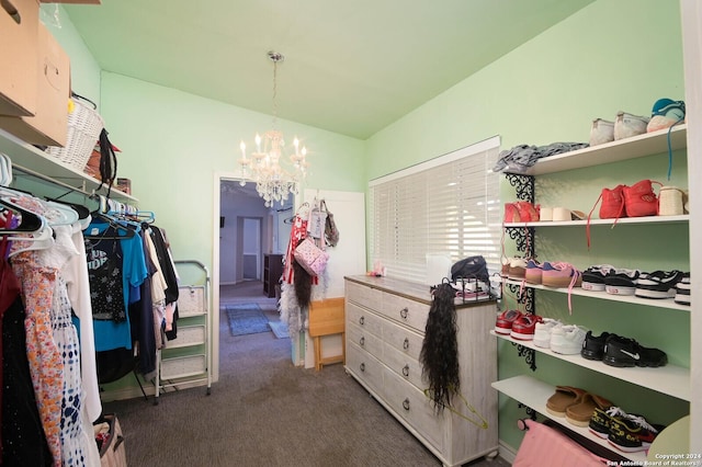 spacious closet featuring dark carpet and a notable chandelier