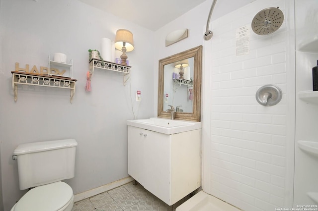 bathroom with tile patterned flooring, toilet, vanity, and walk in shower