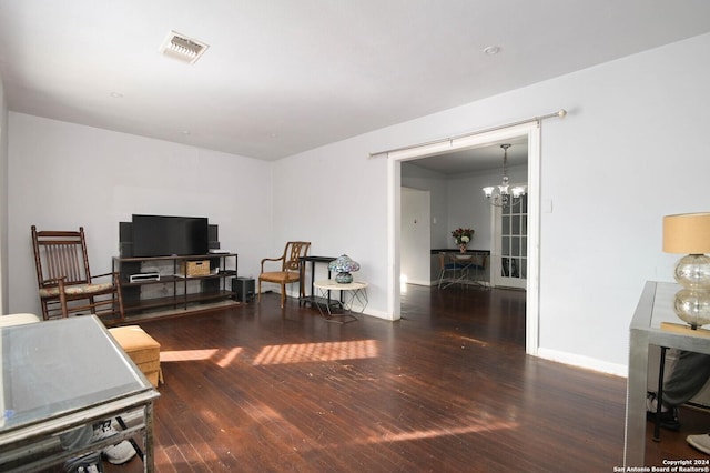 living room featuring dark wood-type flooring and a notable chandelier