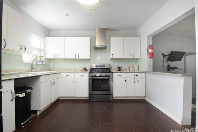 kitchen with dark wood-type flooring, sink, wall chimney range hood, white cabinets, and stainless steel gas stove