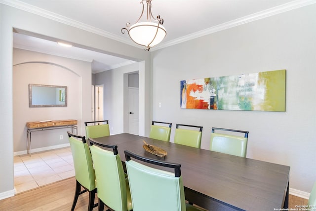 dining space featuring crown molding and light wood-type flooring