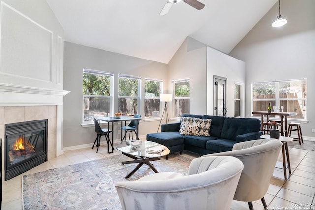 tiled living room featuring ceiling fan, a fireplace, and high vaulted ceiling