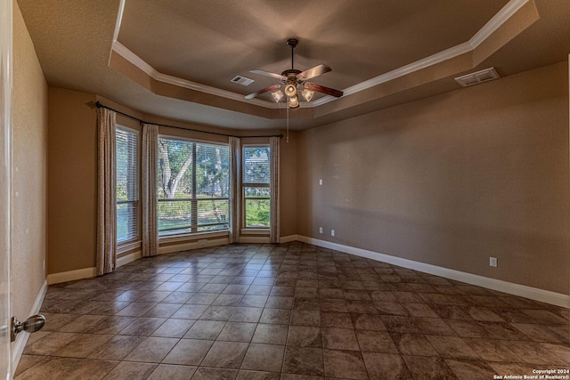 empty room featuring ceiling fan, crown molding, and a tray ceiling