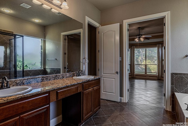 bathroom featuring tile patterned flooring, vanity, ceiling fan, and a tub to relax in