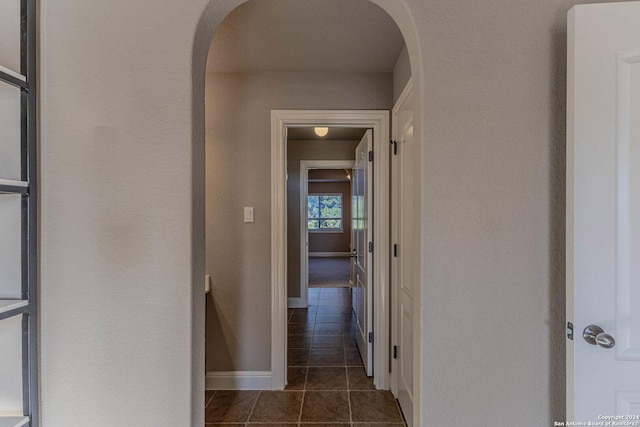 corridor featuring dark tile patterned flooring