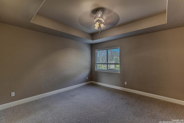 unfurnished room featuring carpet, a raised ceiling, and ceiling fan